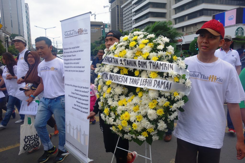 Para penyintas Bom Thamrin berjalan bergandengan tangan menuju pos polisi di perempatan Sarinah, Jl. MH Thamrin, Jakarta Pusat dalam rangka peringatan 2 tahun Bom Thamrin